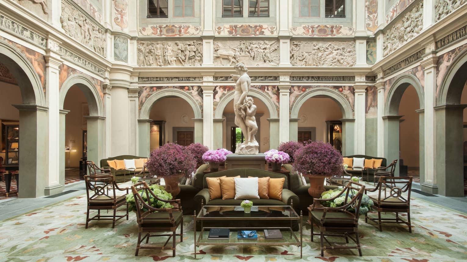 Hotel lobby sofas, chairs under statue, high ceilings and ornate walls