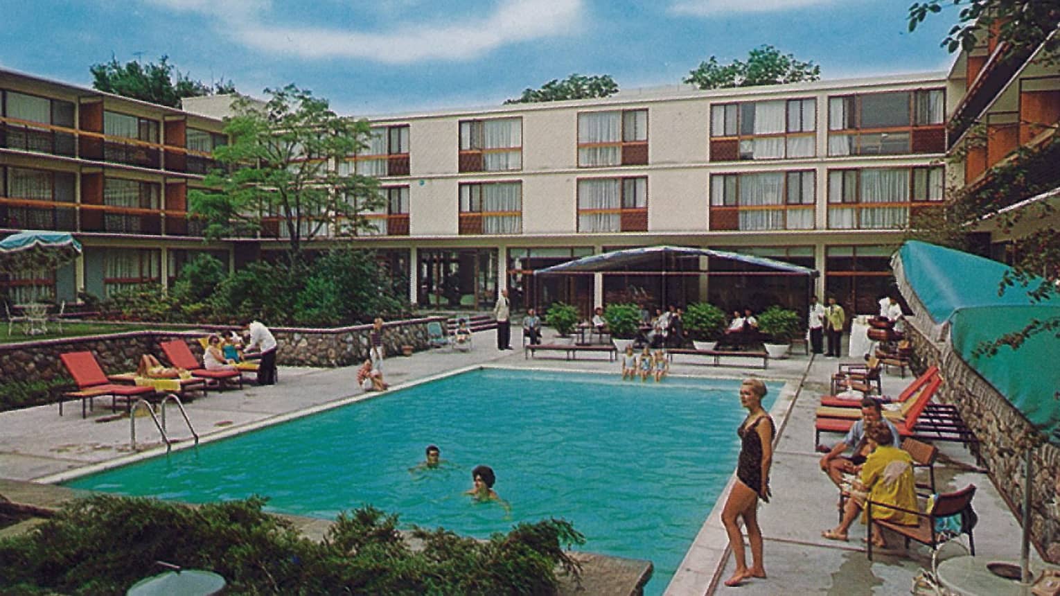 Historic 1960s photo of guests enjoying outdoor swimming pool, deck at Four Seasons Hotel