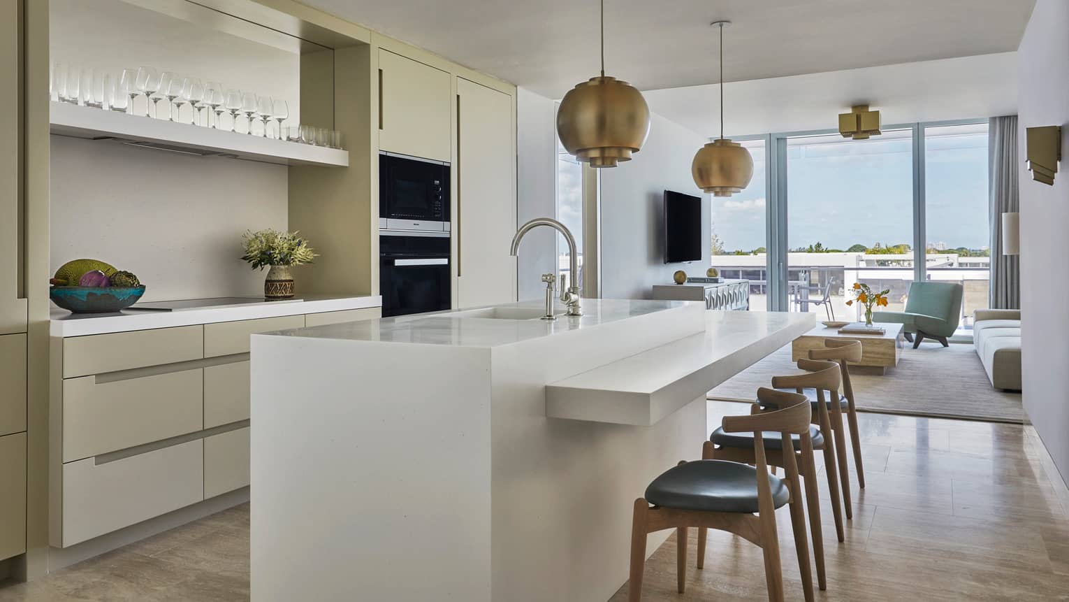 Long white island counter with stools in bright, modern kitchen
