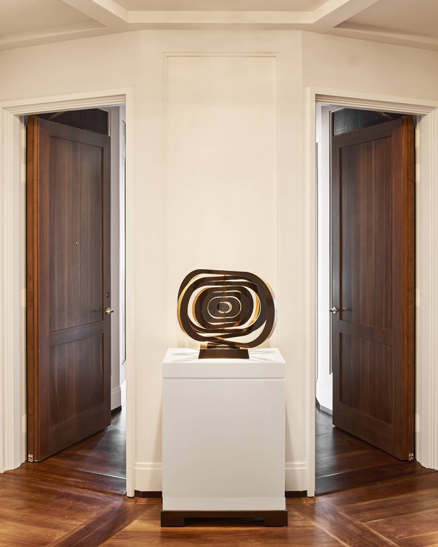 Abstract art sculpture on display in between two wooden doors