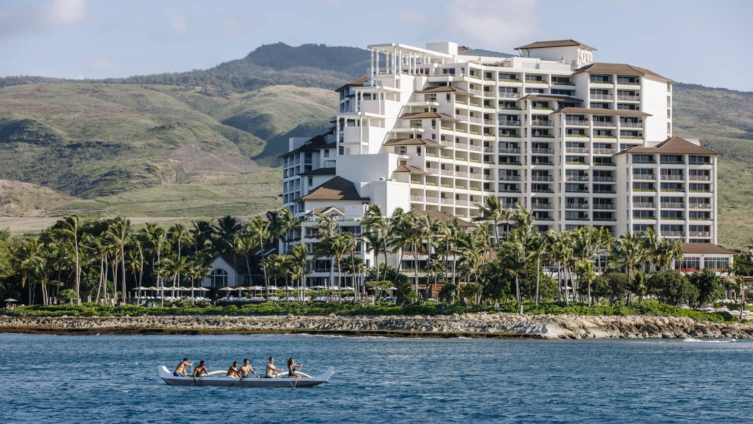 An outrigger canoe paddles past the Hotel