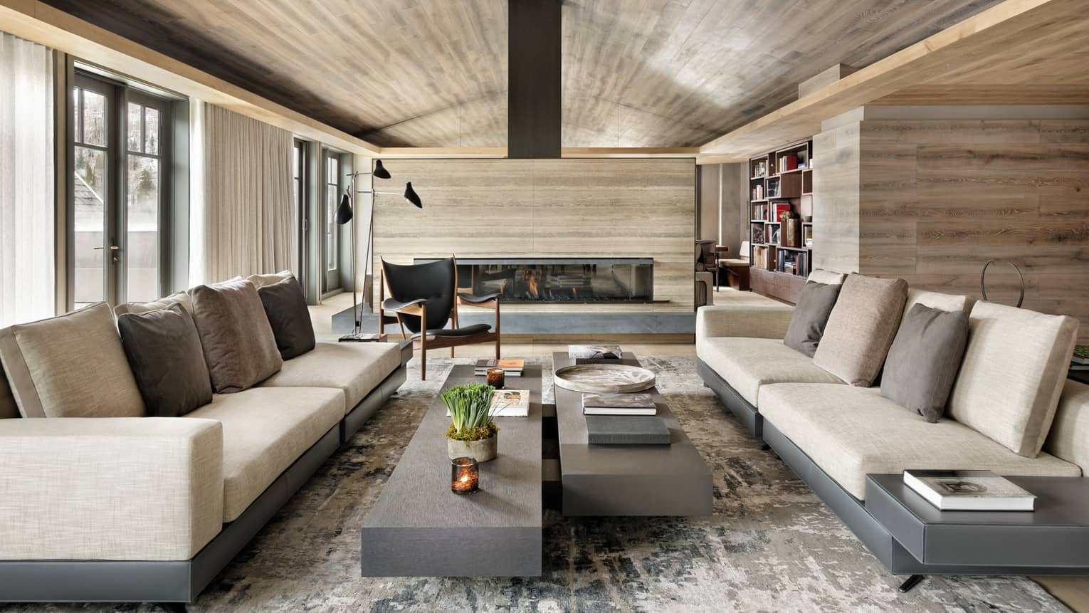 Long linen sofas, slate coffee tables under modern light wood ceiling, fireplace
